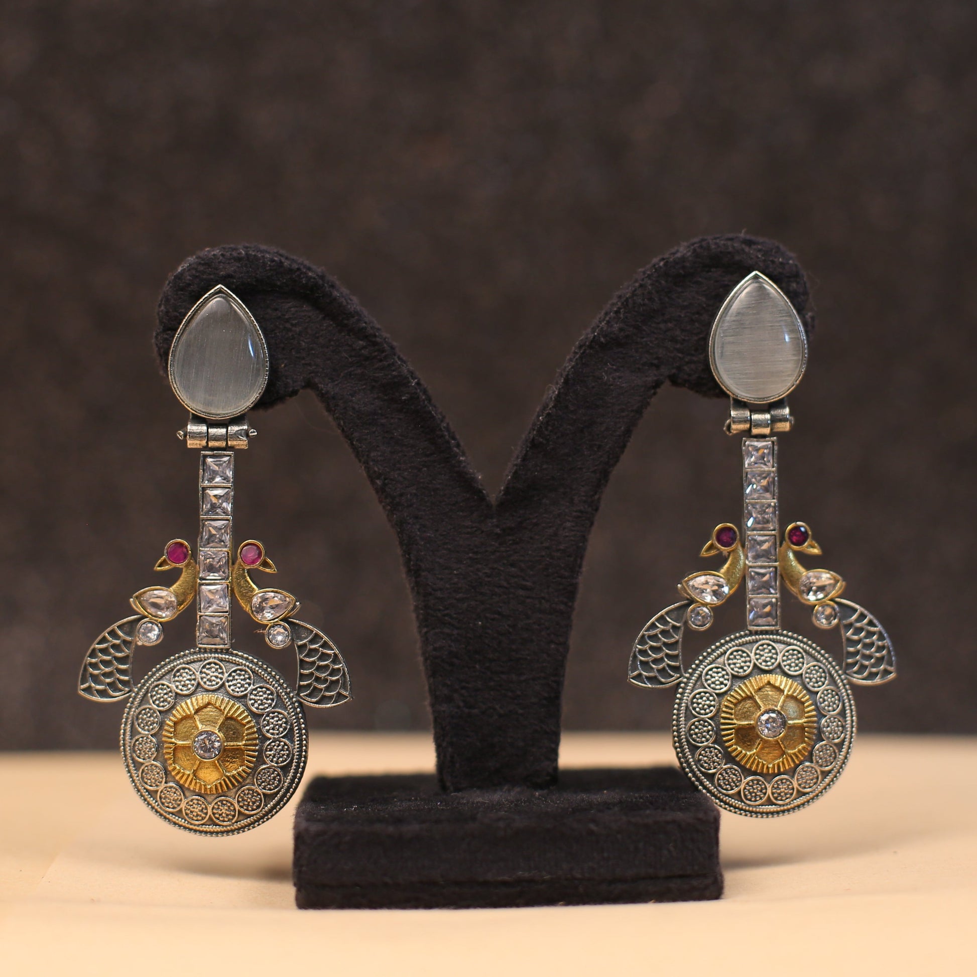 Introducing our stunning Gemstone CZ Dual tone Peacock Earrings! These gorgeous earrings feature sparkling gemstones that will catch the light and make you shine. The dual tone color adds a unique touch, while the peacock design represents beauty, luck, and prosperity. Elevate any outfit with these statement earrings!

Length - 4"

Width - 2"

Note-

Neckpiece is made of stones/beads/pearls and copper brass alloy and Mix Metal

Colour, shades, texture displayed may slightly vary from the actual product due 